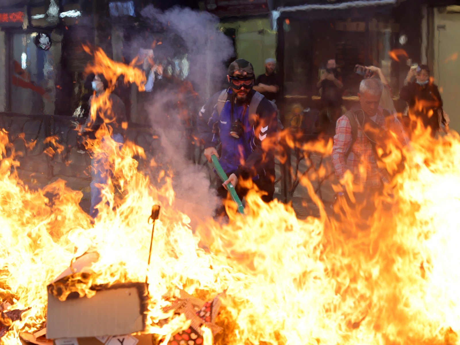 Manifestantes encapuchados junto a una barricada en llamas, en Tirana, el 13 de octubre. Foto: Hameraldi Agolli / AP.